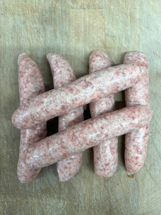 Uncooked sausages arranged on a wooden board